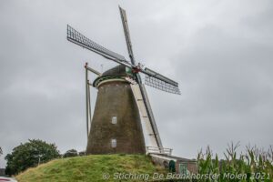 Fietsers en scootmobielen trotseren regen en wind richting Bronkhorster Molen