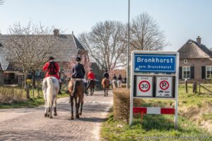 Honden en ruiters volgen spoor door de uiterwaarden